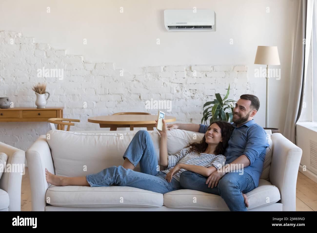 Paare genießen die frische, klimatisierte Klimaanlage im gemütlichen Wohnzimmer Stockfoto