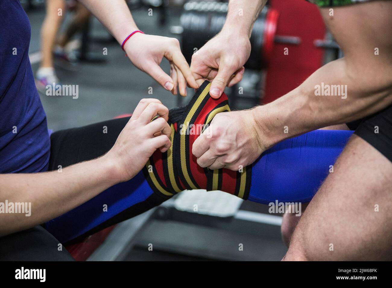 Der Sportler verband das Knie seines Partners mit einer elastischen Bandage Stockfoto