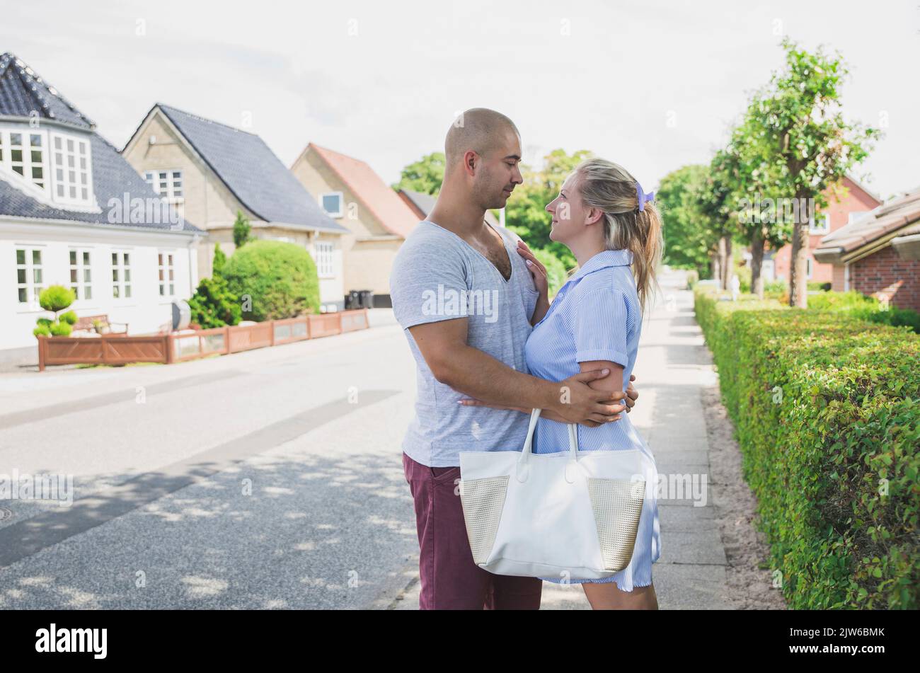 Das junge Ehepaar umarmt sich in einer schönen, gemütlichen Straße Stockfoto