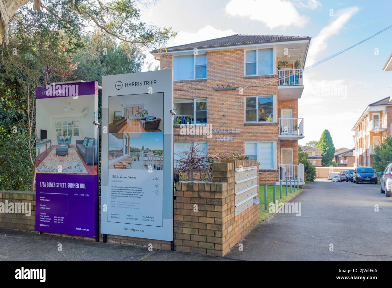 For Sale-Schilder an der Vorderseite eines blonden Wohnblocks aus Ziegelsteinen aus den 1960er Jahren in Summer Hill, Sydney, New South Wales, Australien Stockfoto