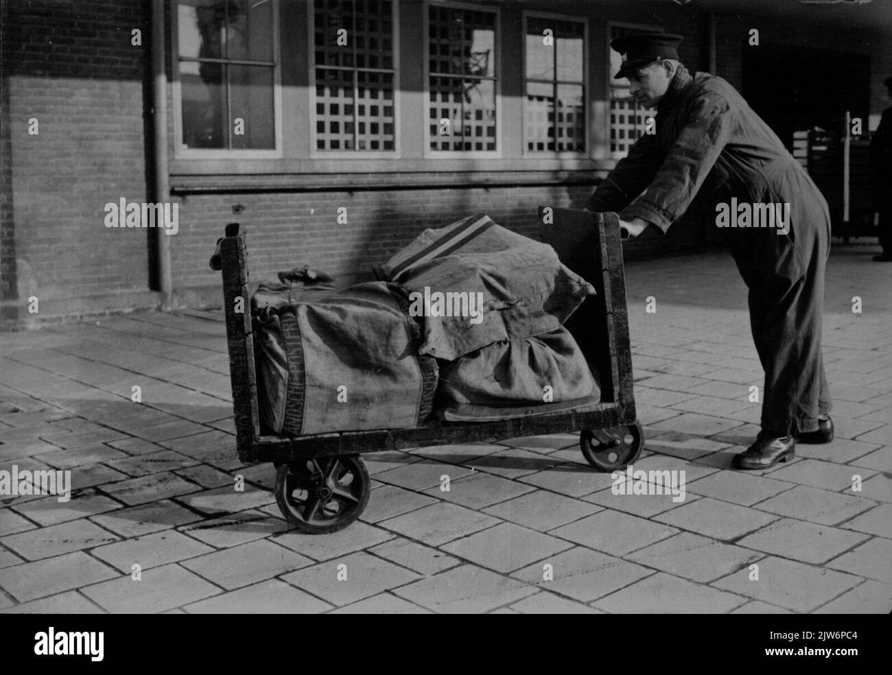 Bild eines Beamten des P.T.T. Mit einem Wagen mit Brieftaschen am Postamt des Bahnhofs (Laan van Puntburg 5) in Utrecht. Stockfoto