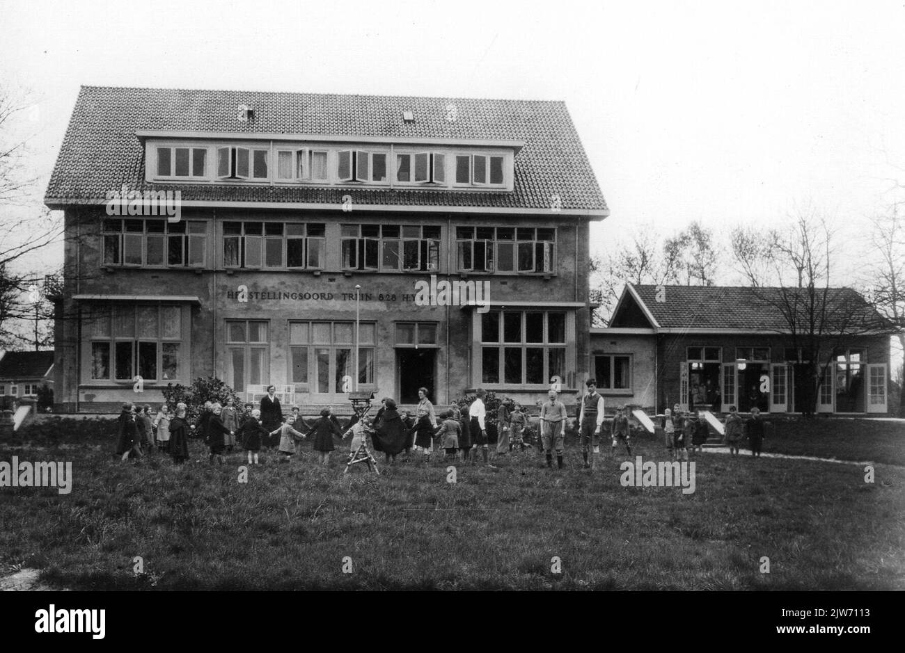 Blick auf den Reparaturresortzug 8,28 H.IJ.S.M. Für Kinder (Kolonieweg) in Soest, nach der Renovierung, mit ein paar Kindern spielen auf dem Rasen. Stockfoto