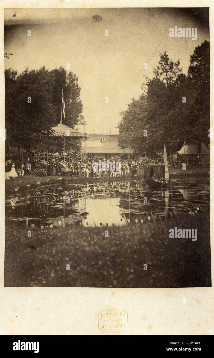 Gesicht zum Festgelände auf der Nieuwe Baan in Utrecht mit Teilnehmern der Maskerade anlässlich des 45.-jährigen Universitätsjubiläums (17-22. Juni 1861) Während der Matinée Musicale, die vom Musikkorps der Stedelijke Schutterij.n.b.aufgeführt wird, wird der Straßenname Nieuwe Baan später in Snellenlaan geändert. Stockfoto