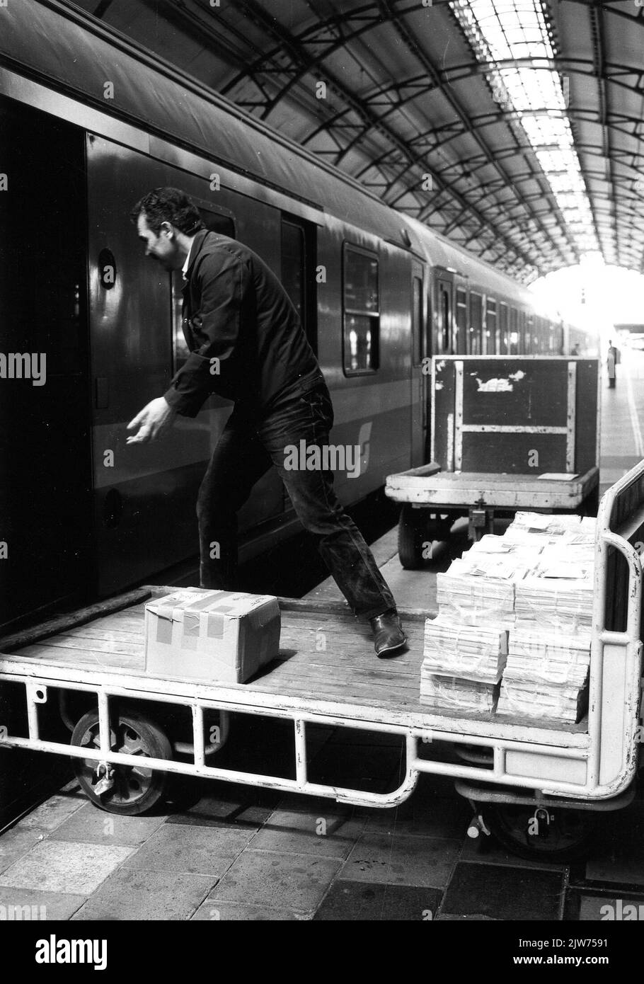 Bild vom Entladen von Paketen aus dem Gepäckwagen eines internationalen Zuges auf dem Bahnsteig des N.S. Bahnhofs Utrecht et al. In Utrecht. Stockfoto