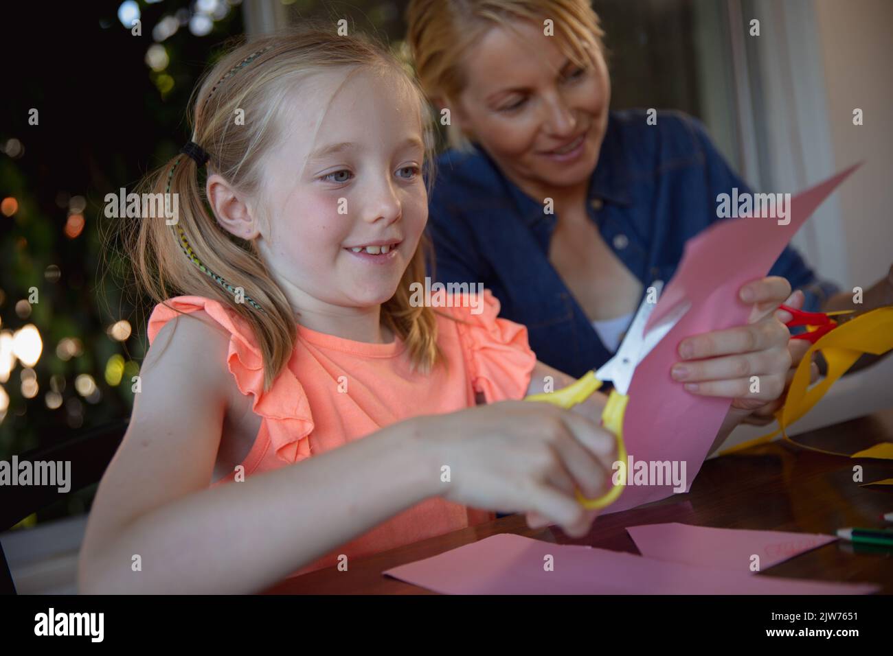 Mutter und Tochter schneiden zusammen farbige Papiere Stockfoto