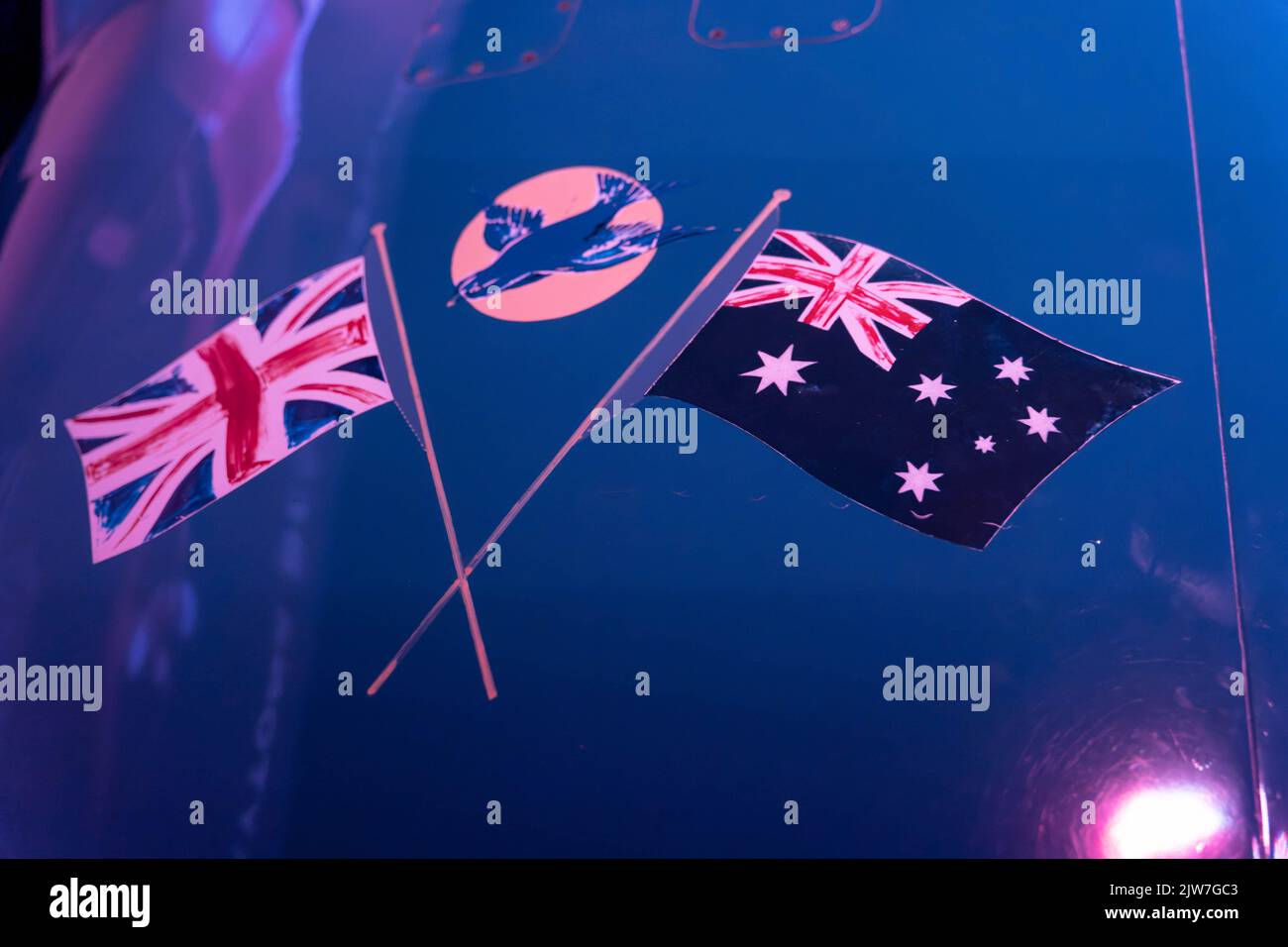 Britische und australische Flaggen kreuzten sich zusammen mit dramatischer Beleuchtung und Reflexionen Stockfoto