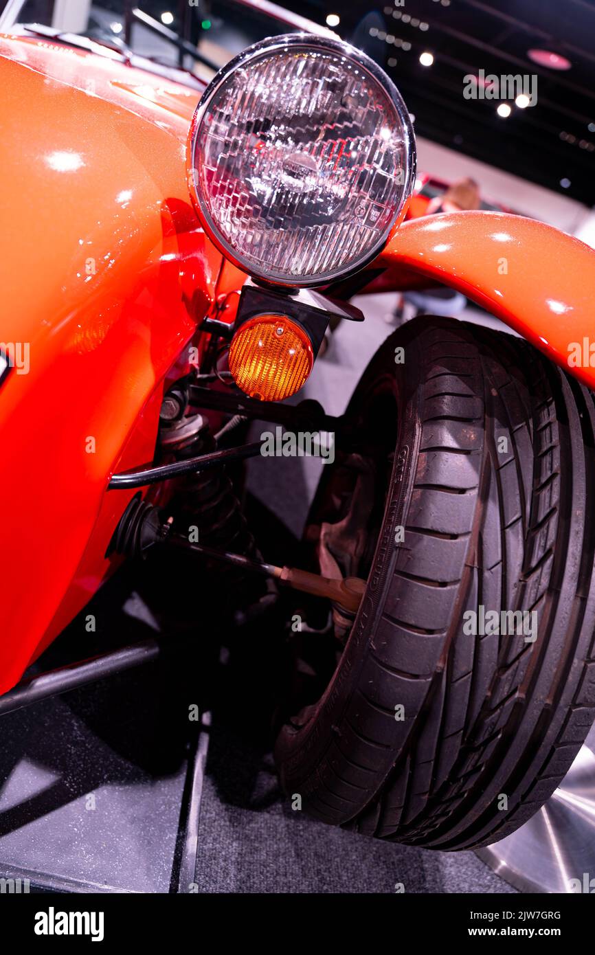 Klassische orangefarbene Sportwagen-Vorderräder und Scheinwerfer auf der Motorshow Stockfoto