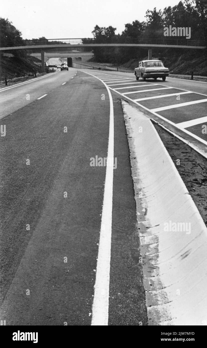 Blick auf die Provinzstraße P14 (Nieuwe Dolderseweg) in Den Dolder, von Süden, mit einem separaten Fahrradweg und dem Eisenbahnviadukt im Hintergrund. Stockfoto