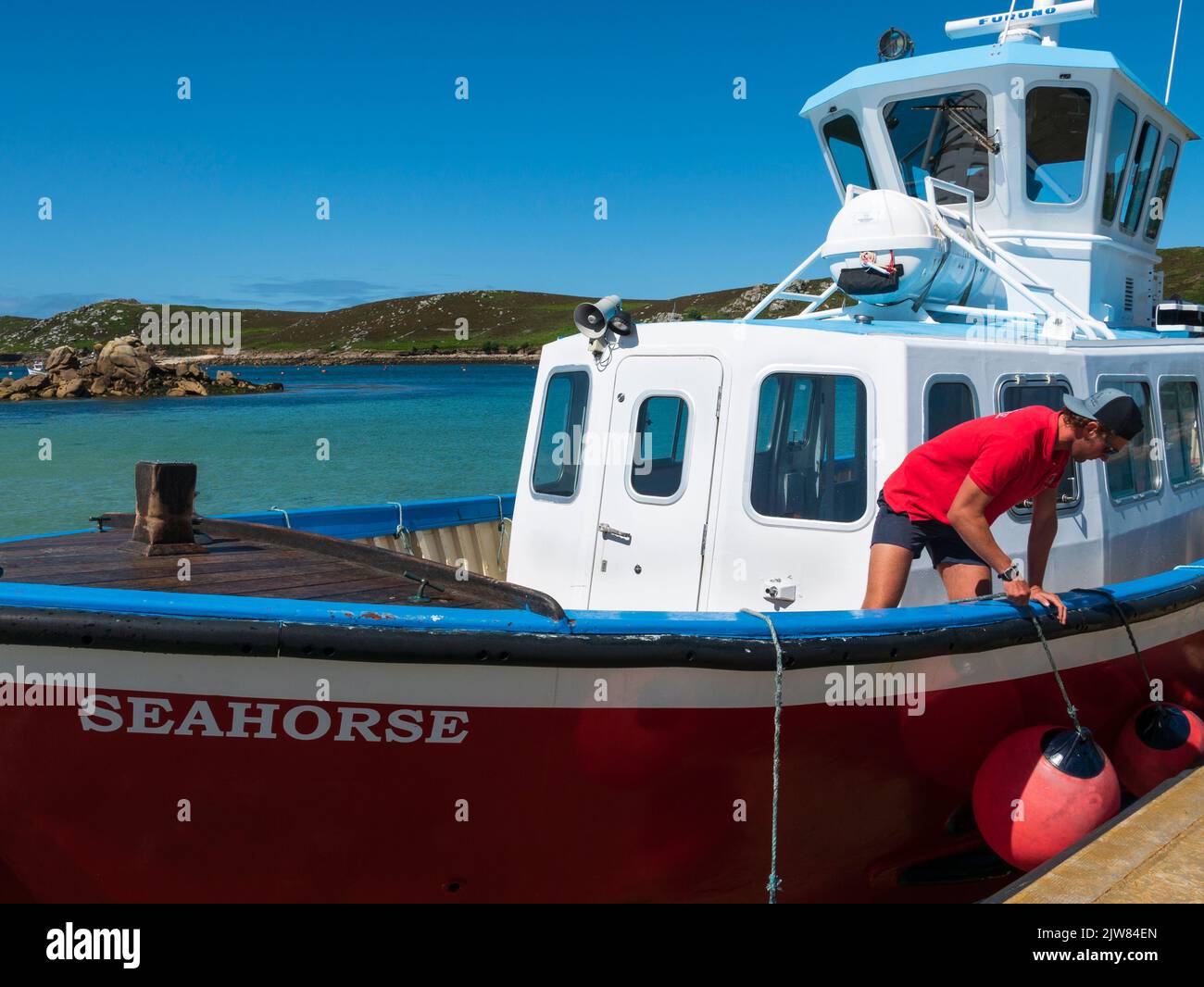 Bootsmann, der das Seepferd-Interinselboot auf dem Kai anlandet, Bryher, Isles of Scilly, Cornwall, England, VEREINIGTES KÖNIGREICH. Stockfoto