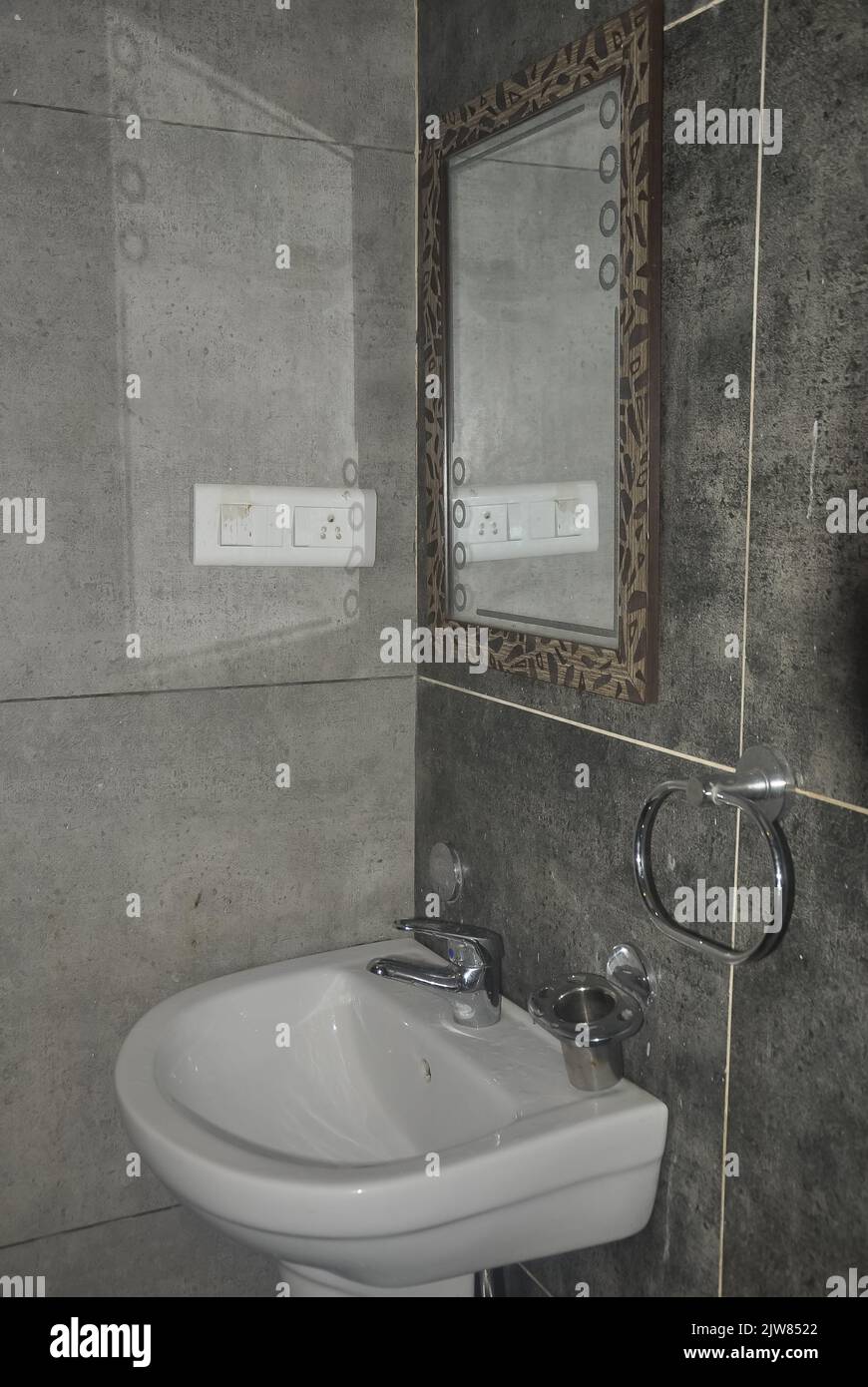 Keramikwaschbecken und Spiegel an der gefliesten Wand im modernen Badezimmer Stockfoto