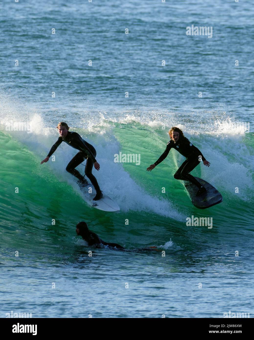 Tandem-Surfen auf einer atemberaubenden aquafrünen Welle in Porthelven, nur fehlt ein Surfer am Ende der Welle. Stockfoto