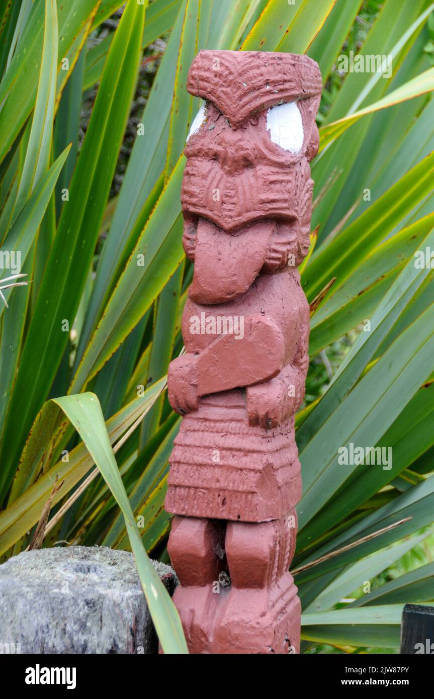 Einer der hölzernen geschnitzten Maori-Götter im einzigen lebenden Maori-Dorf Neuseelands liegt in der geothermischen Whakarewarewa in Rotorua in der Bay of P Stockfoto