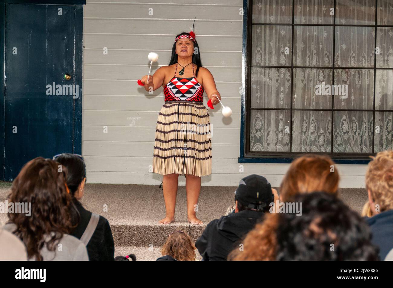 Eine Maori in ihrem traditionellen Tanzkleid bei einem kulturellen Tanzkonzert für Besucher, die das einzige lebende Maori-Dorf Neuseelands besuchen, ist eingerichtet Stockfoto