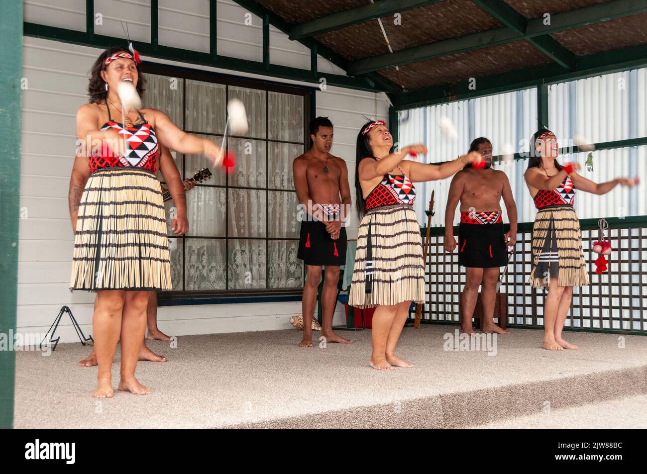 Maori-Tänzer in ihrem traditionellen Tanzkleid bei einem kulturellen Tanzkonzert für Besucher, die das einzige lebende Maori-Dorf Neuseelands besuchen Stockfoto