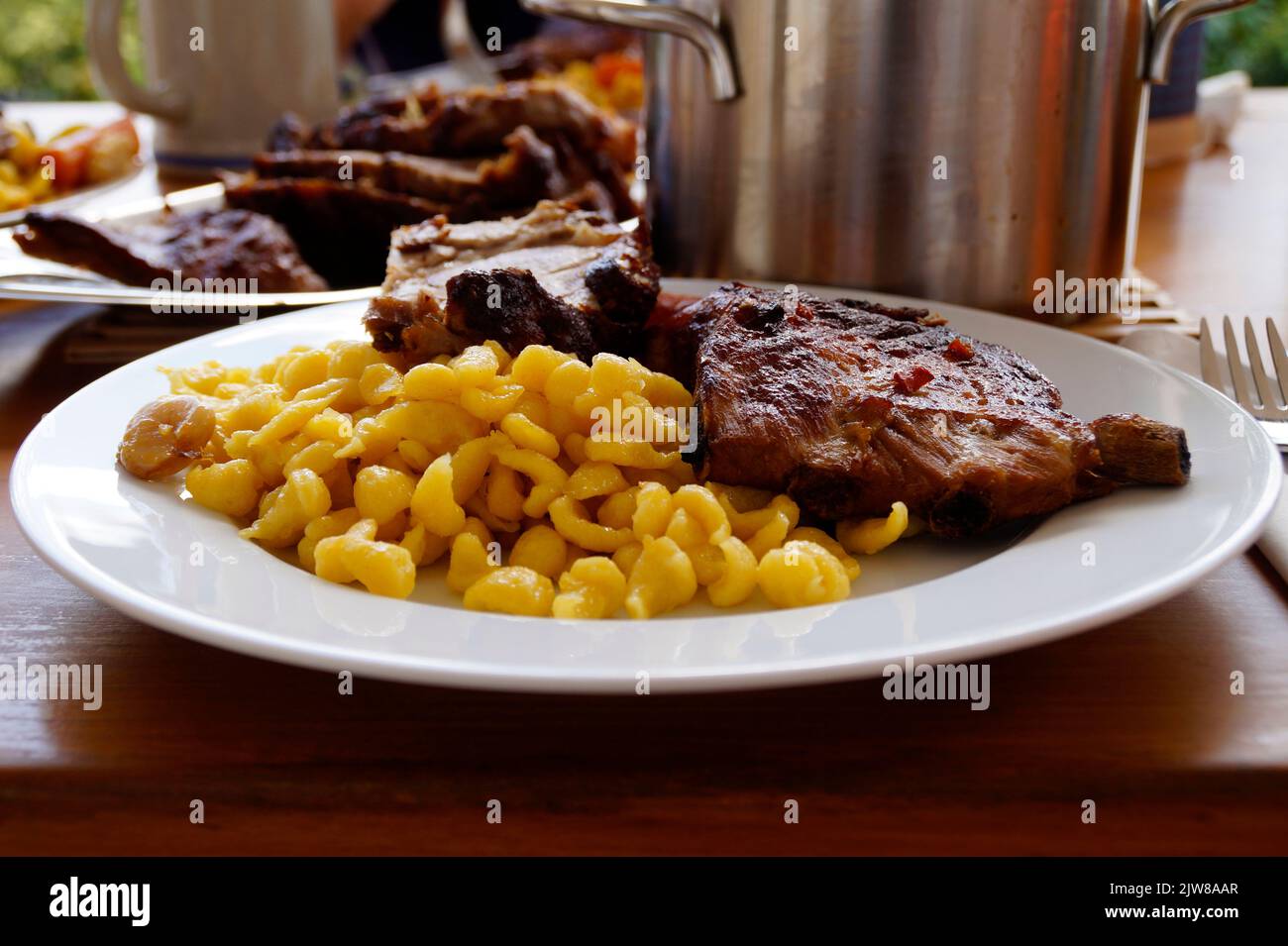 Schwäbische Mahlzeit aus Spätzle oder Spätzli mit gebratenen Spareribs, München, Bayern, Deutschland Stockfoto