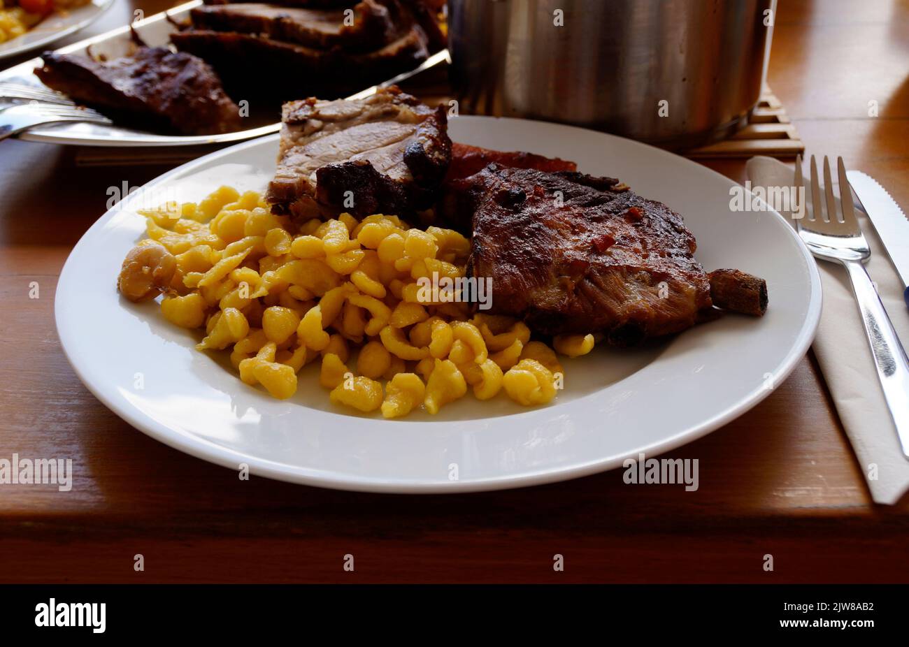 Schwäbische Mahlzeit aus Spätzle oder Spätzli mit gebratenen Spareribs, München, Bayern, Deutschland Stockfoto