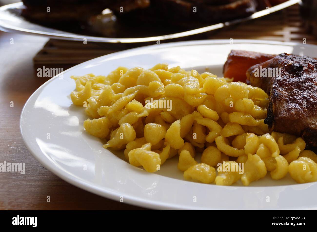 Schwäbische Mahlzeit aus Spätzle oder Spätzli mit gebratenen Spareribs, München, Bayern, Deutschland Stockfoto