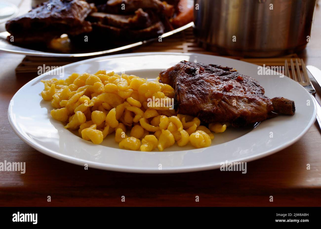 Schwäbische Mahlzeit aus Spätzle oder Spätzli mit gebratenen Spareribs, München, Bayern, Deutschland Stockfoto