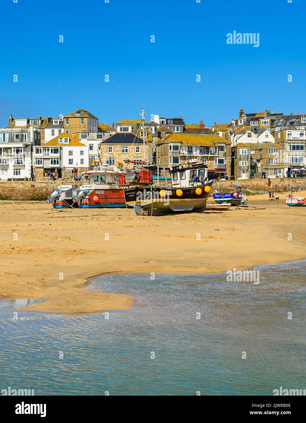 Ebbe am Hafen von St Ives, der sich in Ruhe um die Fischerboote schunkert und auf die Rückkehr der Flut wartet. Stockfoto