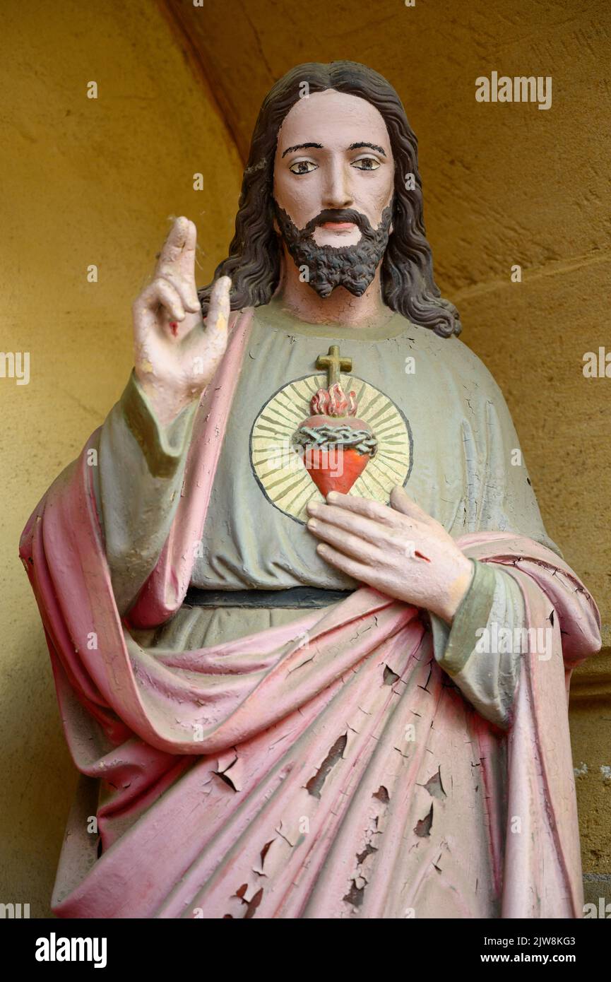 Die Statue des heiligsten Herzens Jesu – ein Altar an der Ecke einer Straße. Bertrange, Luxemburg. Stockfoto
