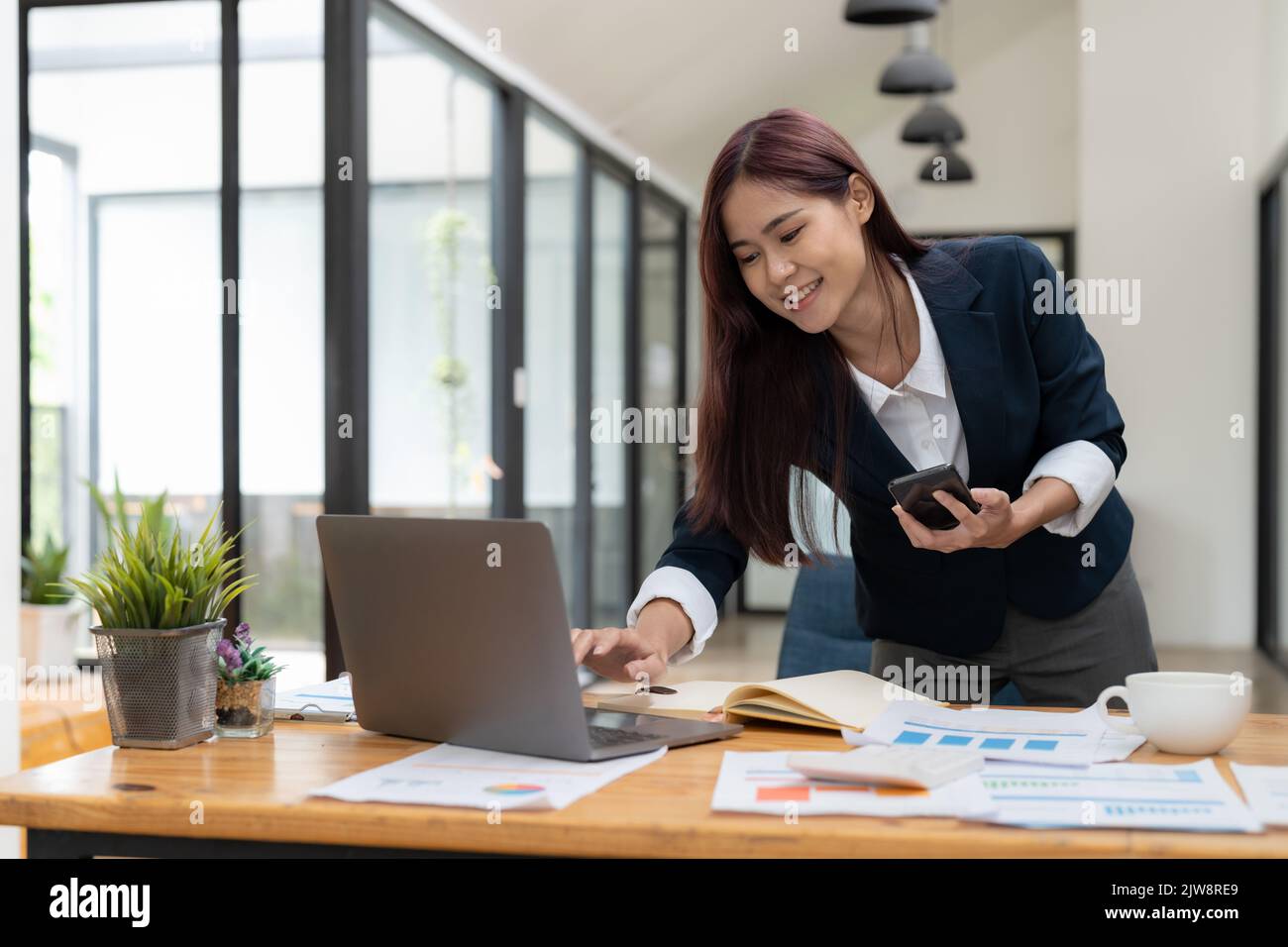Business Asian Frau mit Handy während der Überprüfung einer E-Mail oder Social Media im Internet. Rechnungswesen Finanzkonzept. Stockfoto