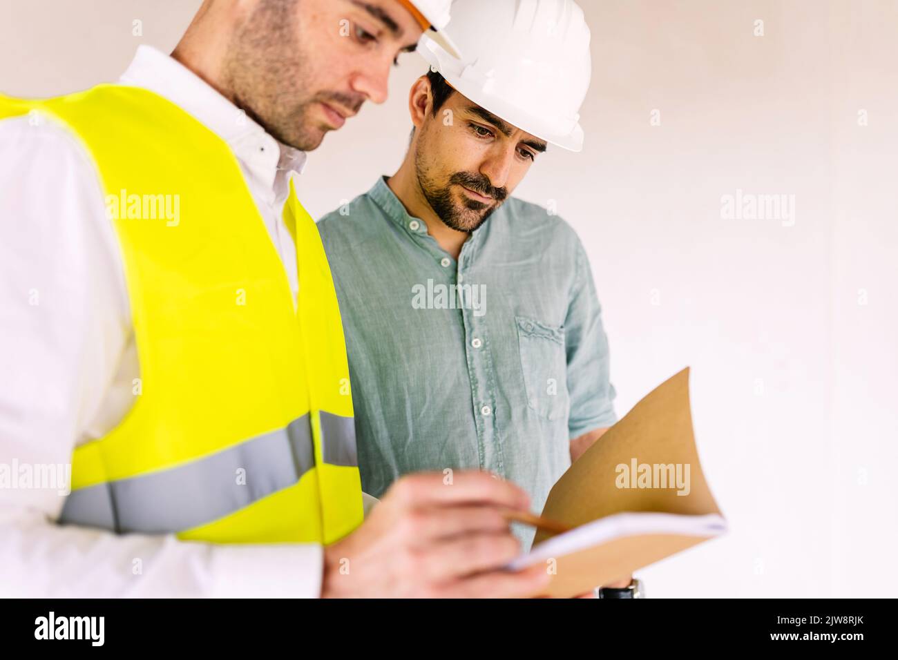 Architektin, der auf der Baustelle mit dem Auftragnehmer männlich diskutiert Stockfoto