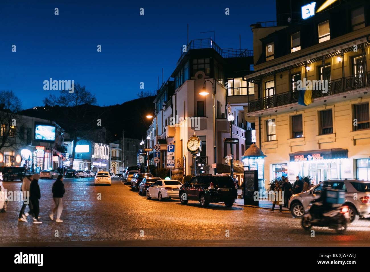 Tiflis, Georgien - 28. März 2022: Verschiedene Autos In Kote Afchasi St, Tiflis Geparkt. Nachtleben In Der Stadt. Beleuchtete Stadt. Touristen Gehen Durch Die Straßen Stockfoto