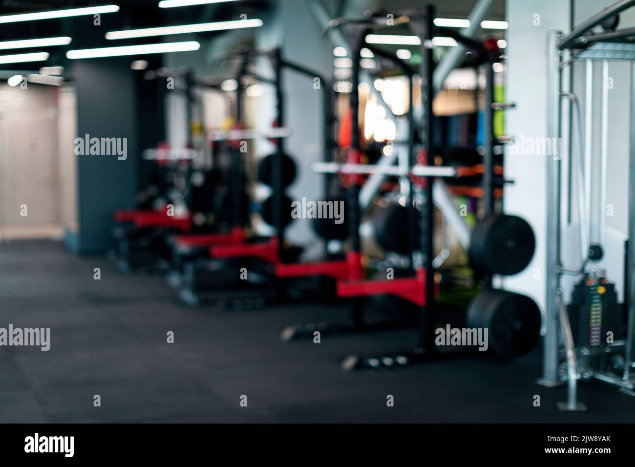 Verschwommener Hintergrund Des Modernen Sport Club Interior Mit Schwergewichtiger Hebeausrüstung Stockfoto