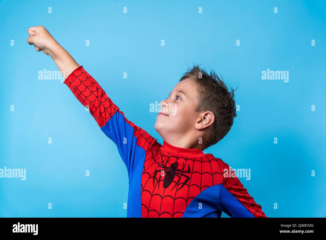 Ein Junge in einem Heldenkostüm. Eine siegreiche Aufwärtsbewegung der Hand Stockfoto