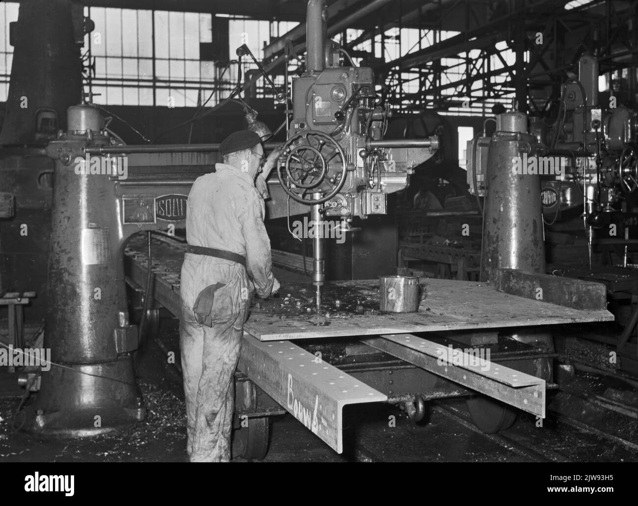 Bild eines Mitarbeiters von Werkspoor in Utrecht mit einer Bohrmaschine beim Bohren der Nieten für einen Teil der Nieuwe-Moerdijk-Brücke. Stockfoto