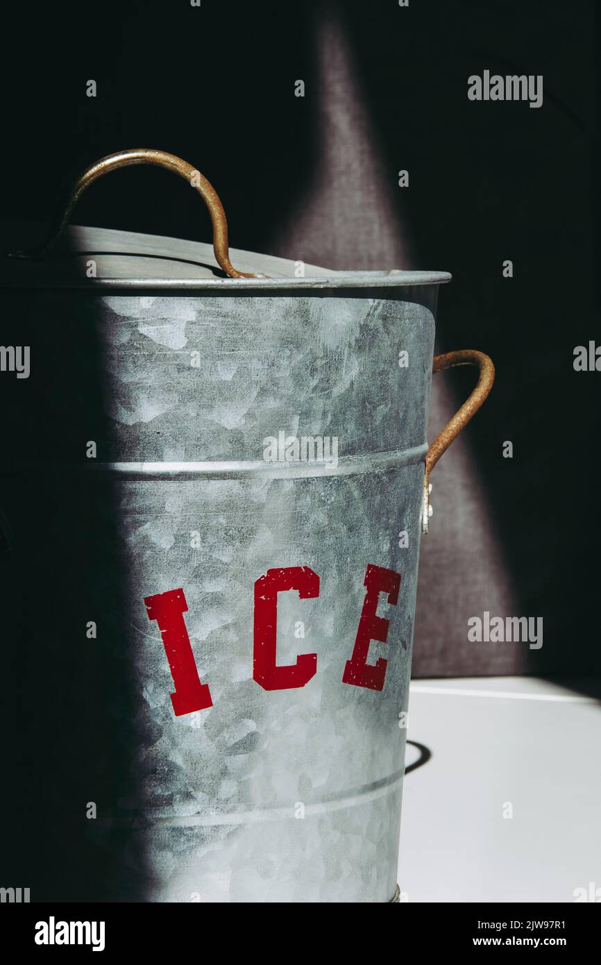 Eiskübel aus Metall mit teilweise beleuchtetem roten Schild Stockfoto