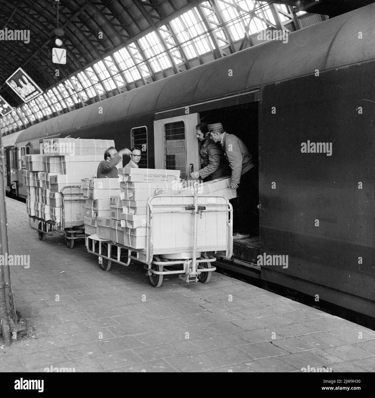 Bild des Ladens von Blumen im Gepäckwagen eines internationalen Zuges auf dem Bahnsteig des N.S. Bahnhofs Amsterdam et al. In Amsterdam. Stockfoto
