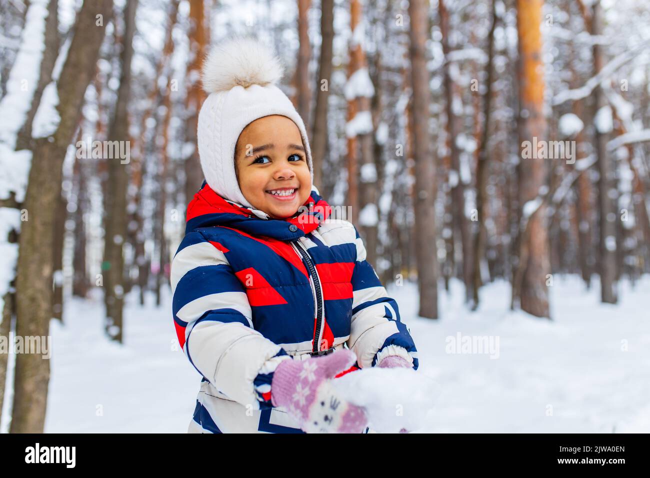 Kleines Mädchen spielt am verschneiten Wintertag im Park Schlittenfahrt den Hügel hinunter Stockfoto