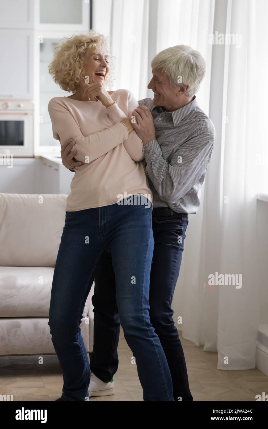 Fröhliches, aufgeregtes Rentnerpaar mittleren Alters, das seinen Hochzeitstag feierte Stockfoto