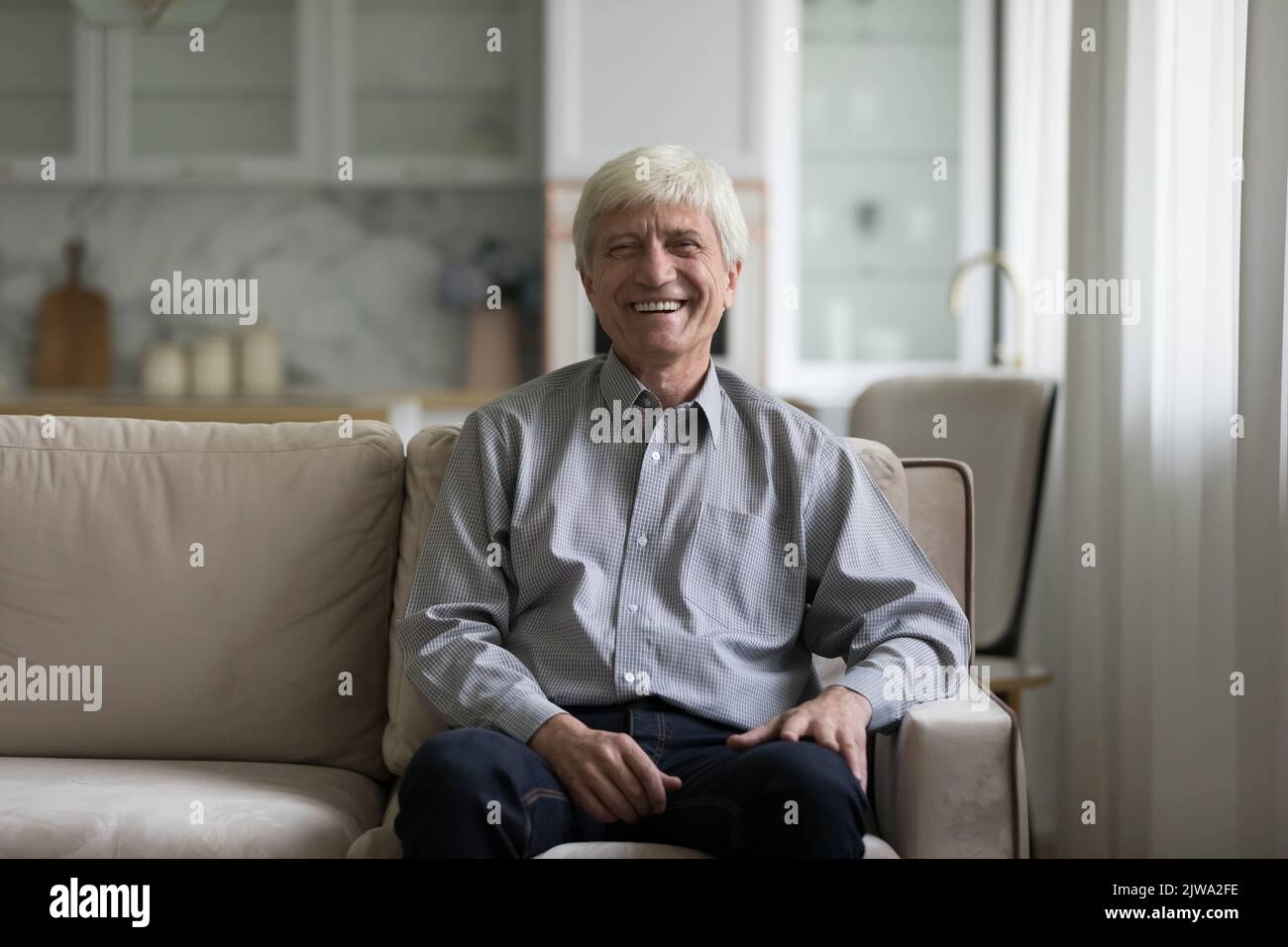 Glücklicher älterer älterer 60s Mann im Innenbereich Stockfoto