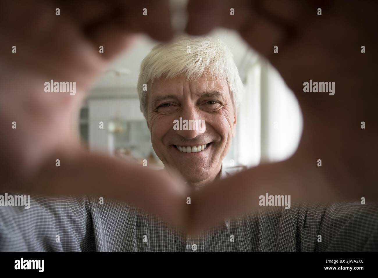 Fröhlicher, fröhlicher älterer Rentner, der die Kamera ansah Stockfoto
