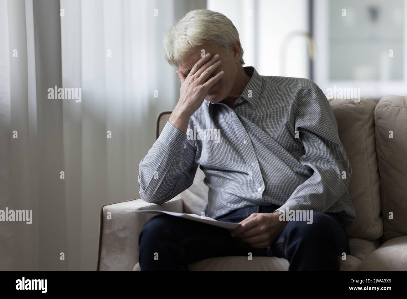 Verzweifelt depressiver älterer Mann, der schlechte schockierende Nachrichten erhalten hat Stockfoto