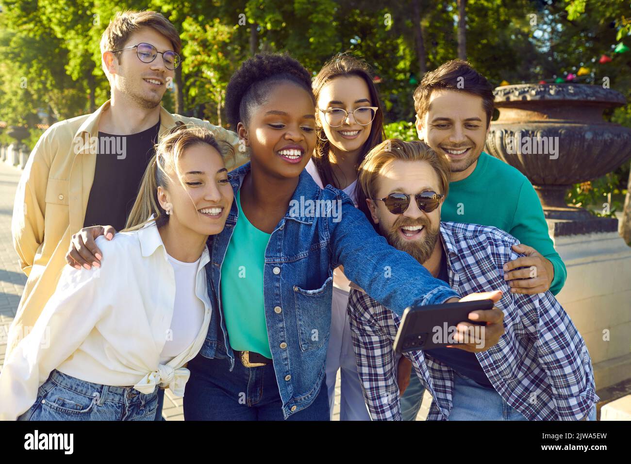 Multiethnische junge glückliche Menschen machen ein kollektives Selfie mit Freunden auf Telefonständen auf der Straße der Stadt Stockfoto