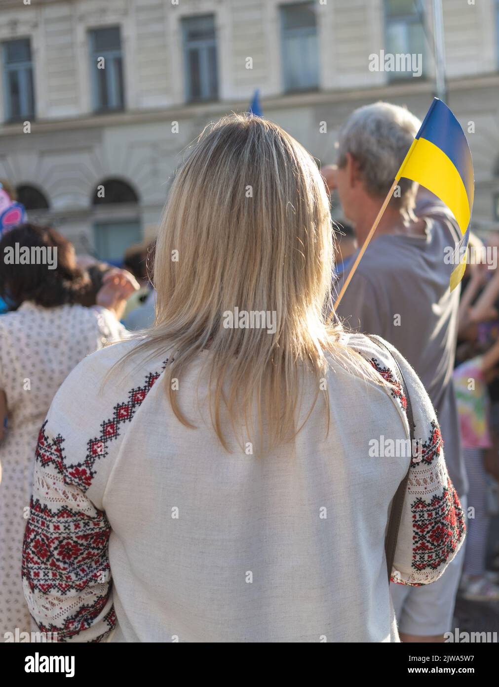 Dame in traditioneller Nationalkleidung mit ukrainischer Flagge Stockfoto