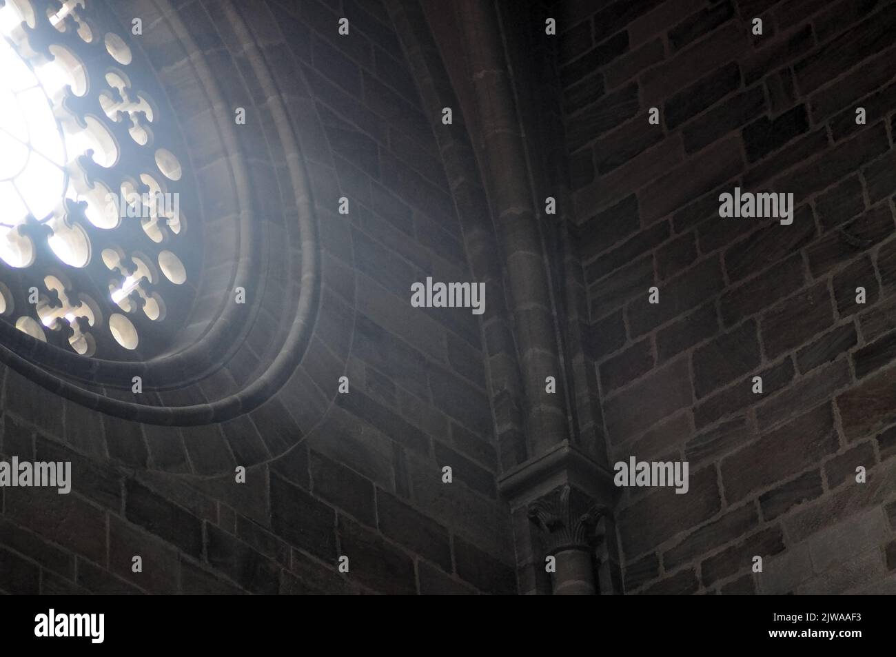 Innenansicht einer europäischen Kathedrale mit dunklen mittelalterlichen Mauern Stockfoto