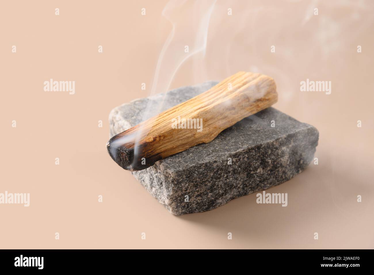 Palo Santo Räucherstäbchen, die auf Stein brennen. Stockfoto