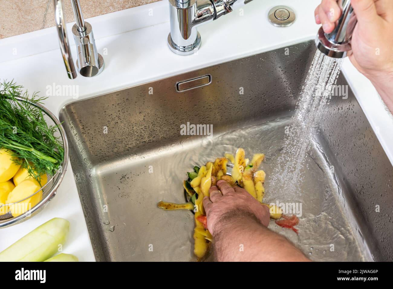Recycling von Lebensmittelabfällen mit einem Entsorger im Spülbecken Stockfoto