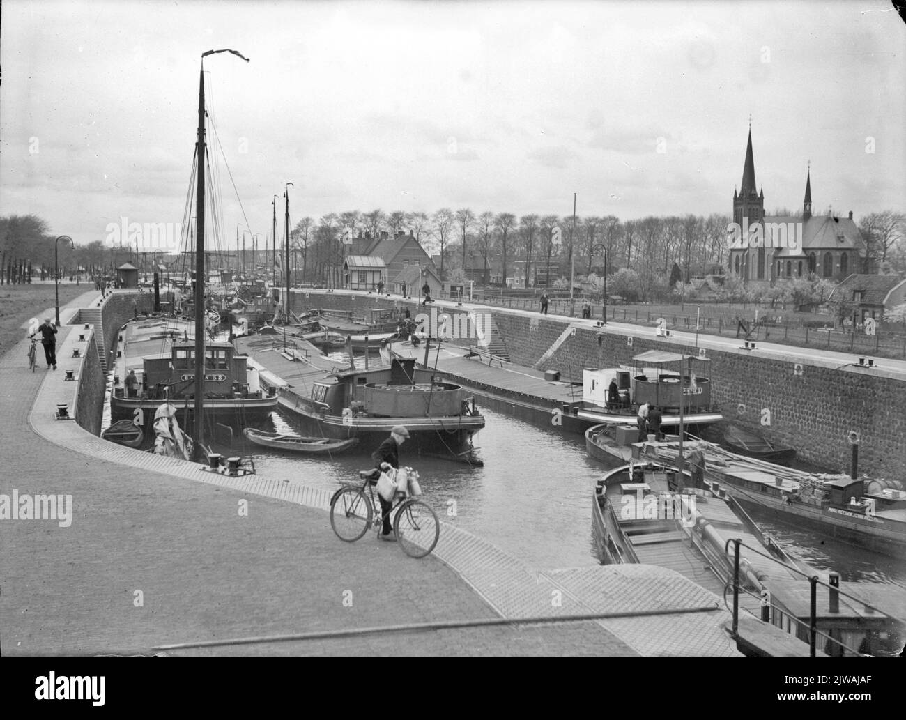 Blick auf die Koninginnen-Schleuse im Merwedekanaal an der Handelskade in Vreeswijk, mit dem St.Barbarakerkk (Koninnenlaan 3) .n.b auf der rechten Seite. Vreeswijk wurde am 1. Juli 1971 in die neu gegründete Gemeinde Nieuwegein aufgenommen. Stockfoto