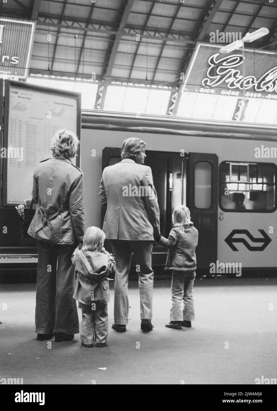 Bild von Zugreisenden an der Abflugzeittafel auf dem ersten Bahnsteig der N.S. Station Amsterdam et al. In Amsterdam. Stockfoto