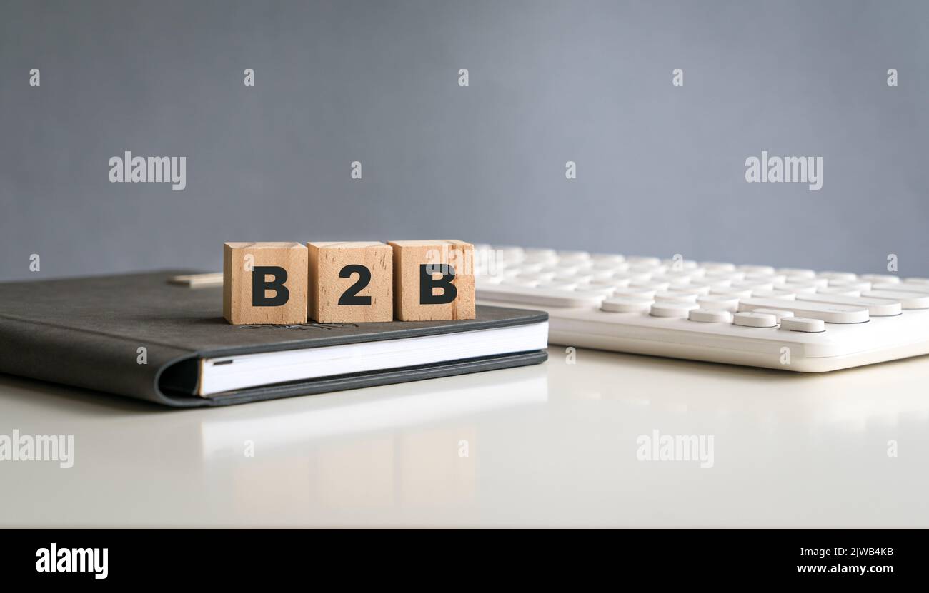 Konzept von B2B. Wort auf Holzwürfeln, auf dem Notizblock und neben der Tastatur. Stockfoto