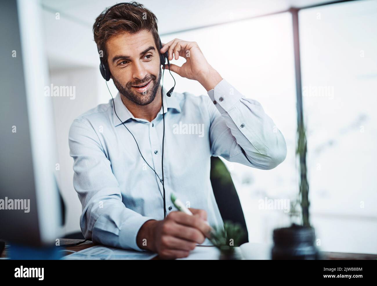 Ein junger Callcenter-Agent, der in einem Büro arbeitet. Stockfoto