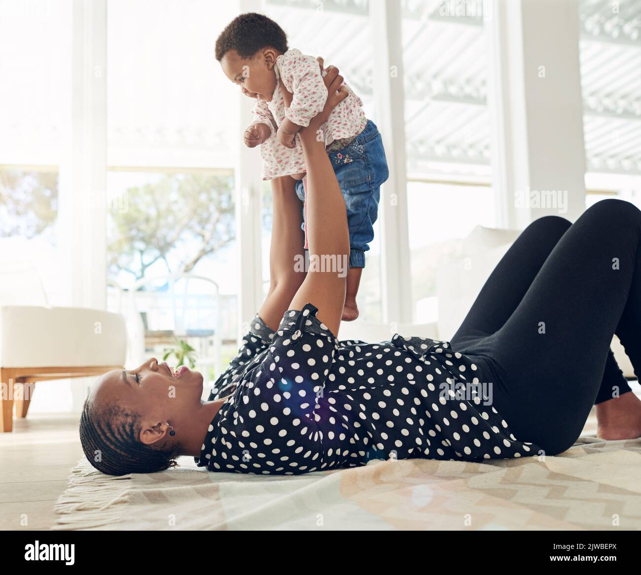 Die wichtigste Person in ihrem Leben. Eine Mutter hält ihr Baby in der Luft. Stockfoto