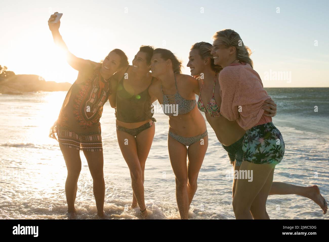 Frauen machen ein Selfie am Strand bei Sonnenuntergang Stockfoto