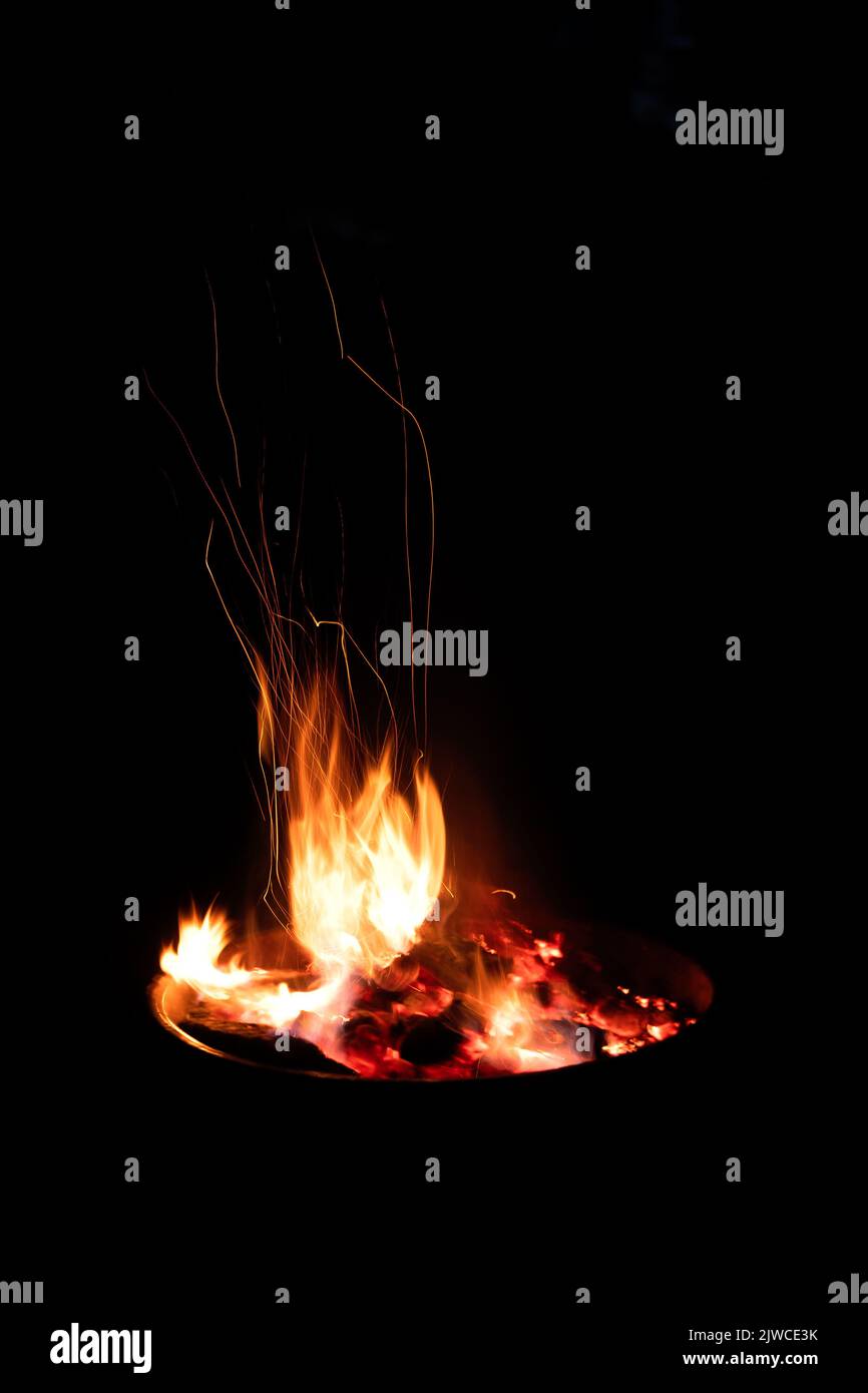Lagerfeuerflamme Funken lange Exposition isoliert auf schwarzem Hintergrund. Feuer funkelt lange Belichtung isoliert auf schwarzem Hintergrund Stockfoto