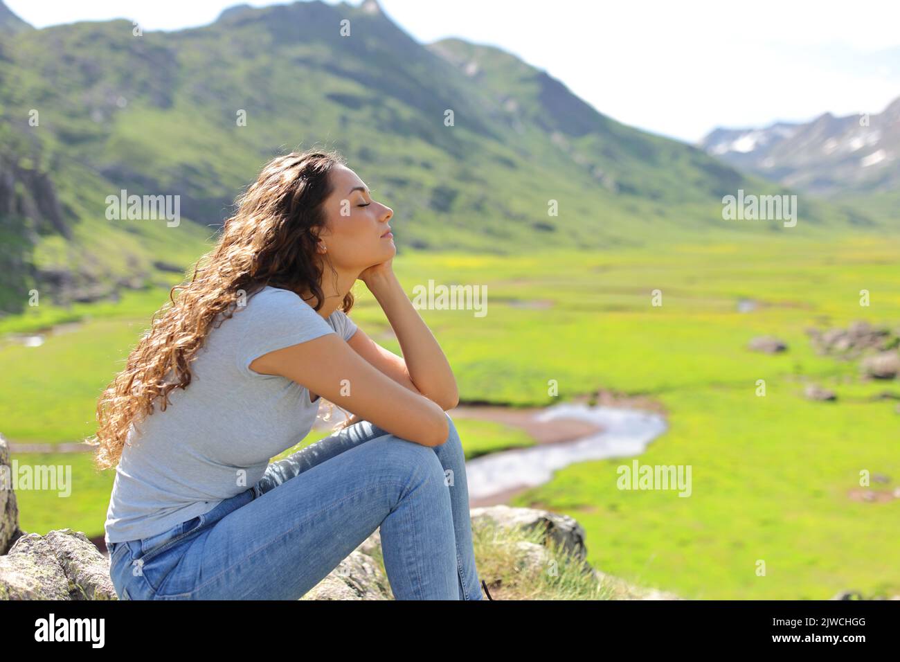 Profil einer entspannenden Frau in einem Bergtal Stockfoto